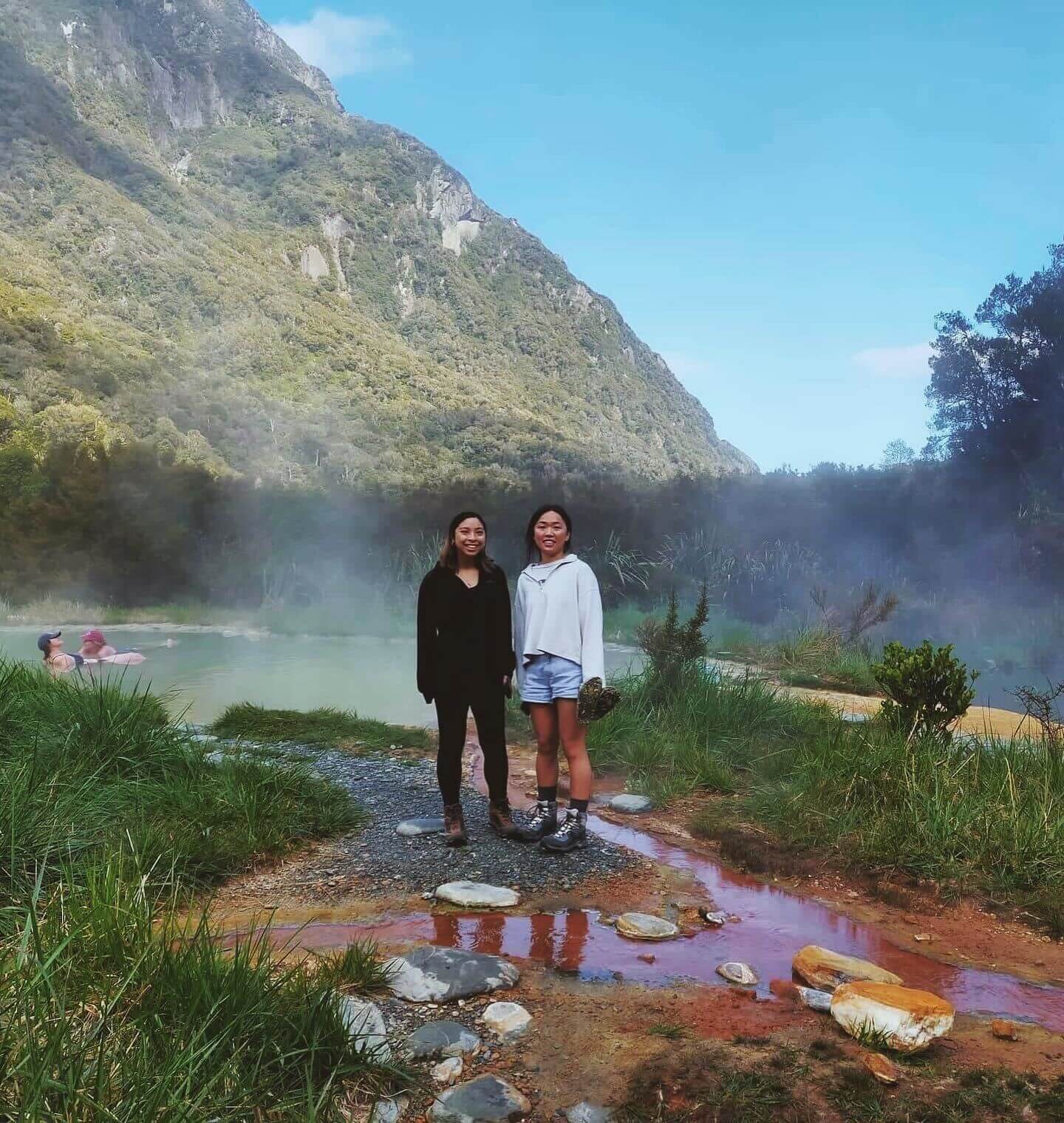 Two people standing in front of mountain