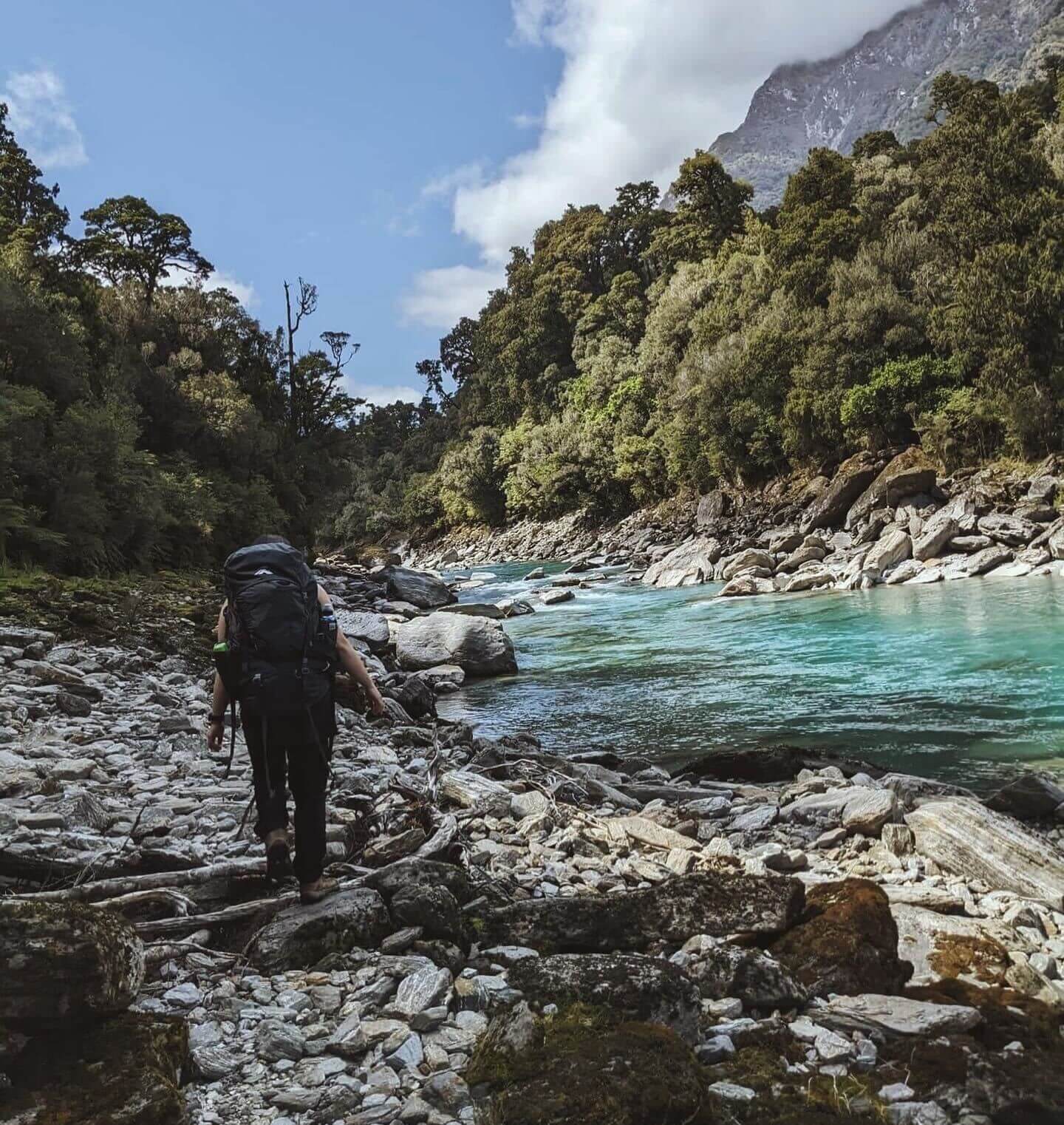 person hiking next to river