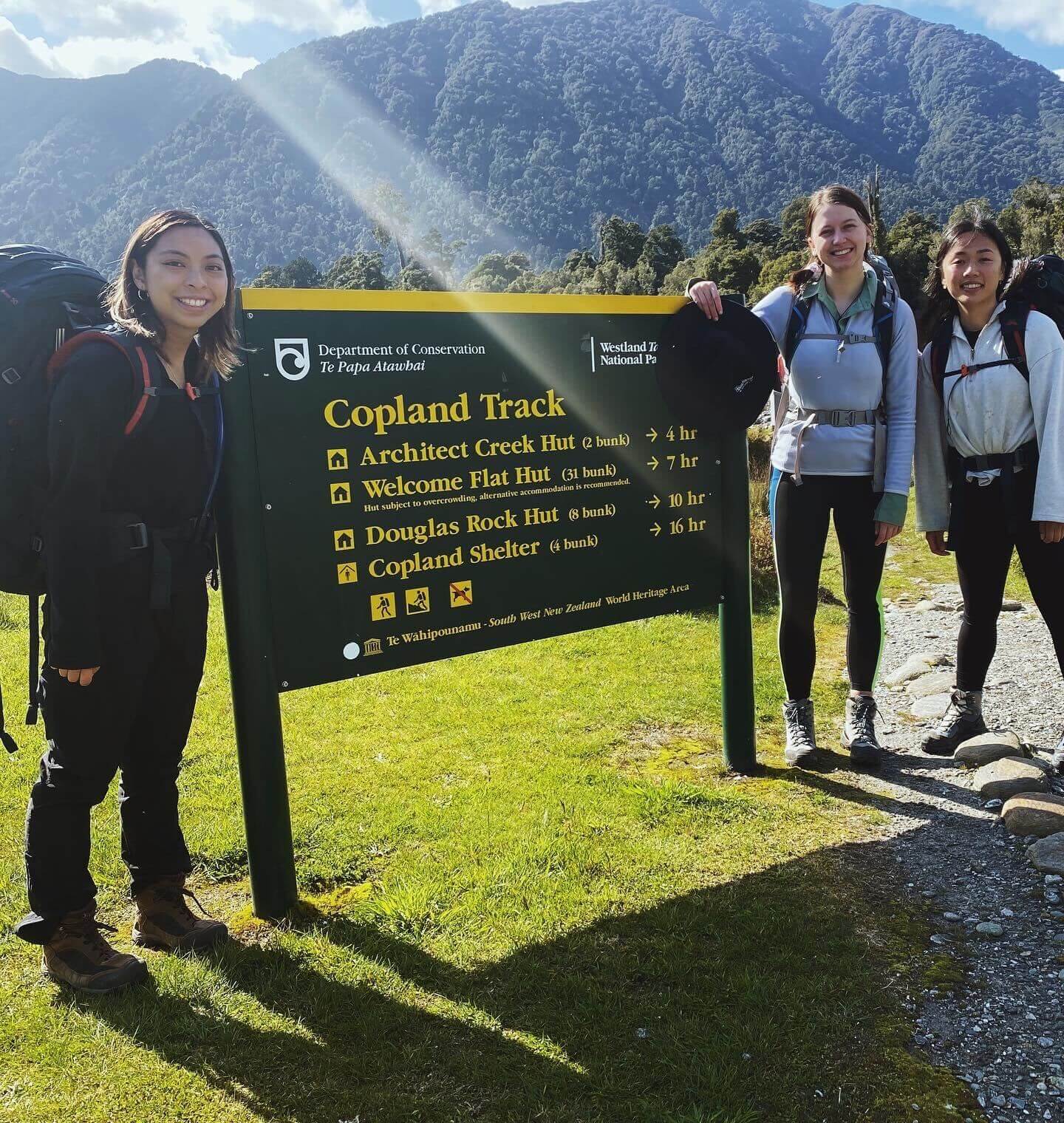 People standing in front of the copland track sign