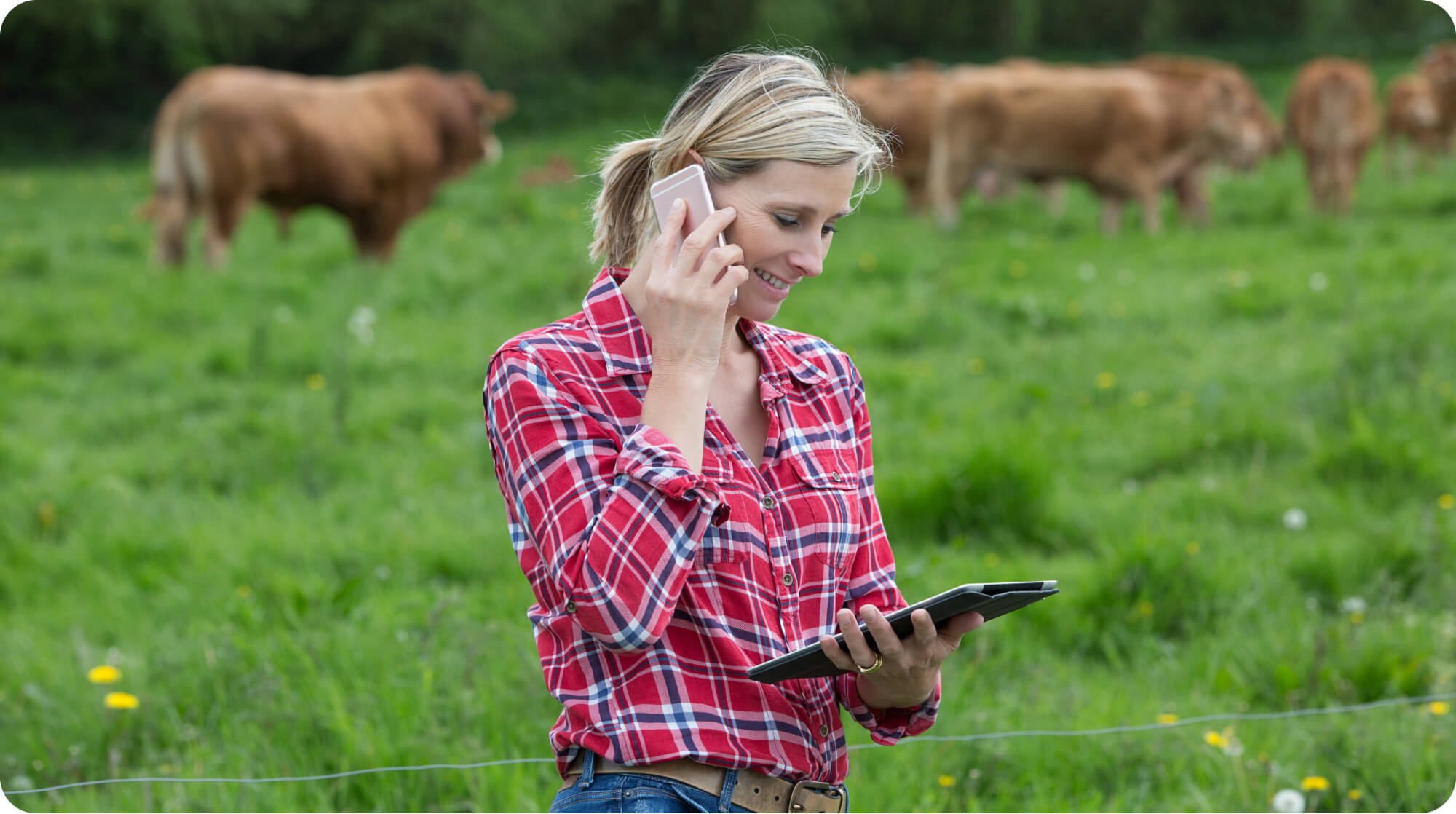 Female land professional on mobile phone and tablet in the field