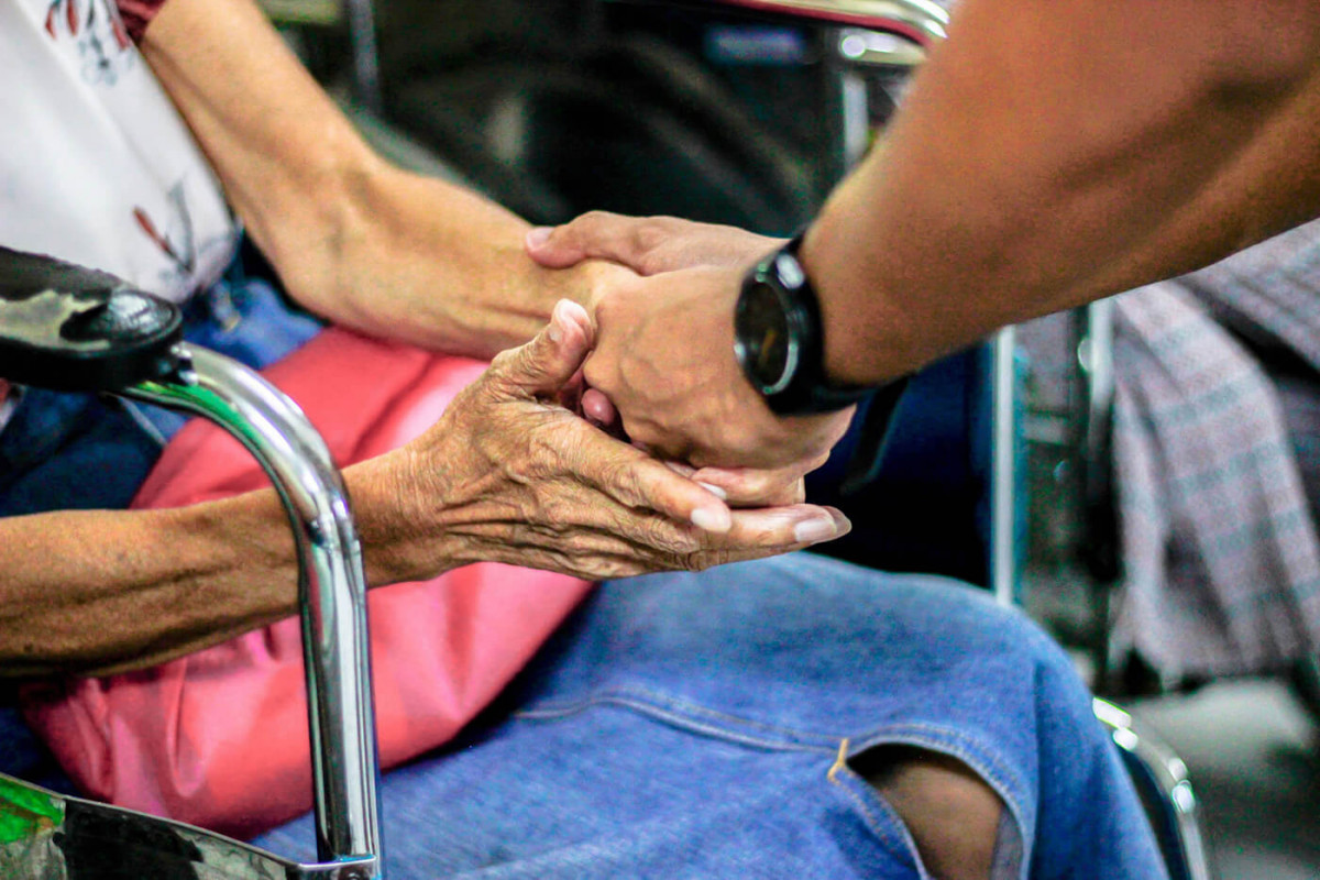 Two people holding hands in a hospital