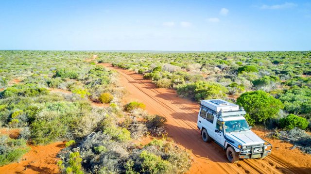 Vehicle driving along a remote Australian outback road in high-risk travel conditions